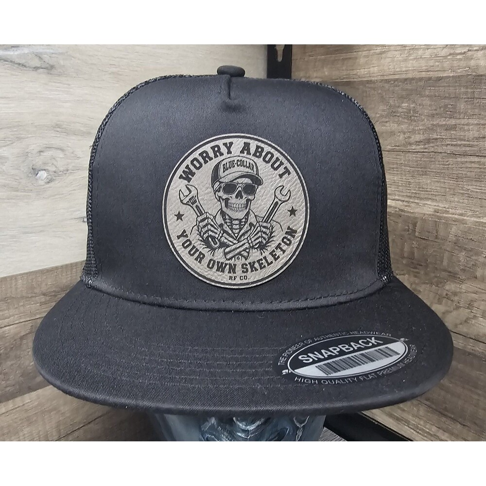 Blue Collar Skull Trucker Hat – “Worry About Your Own Skeleton” Leather Patch